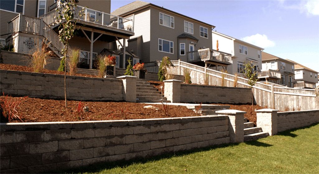 Brent's Landscaping, Dartmouth's top company, transformed this terraced backyard with stone block retaining walls, stairways, and newly planted trees and shrubs. Multi-level homes with balconies highlight their expertise. - Brent's Landscaping
